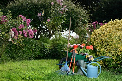 Gardener mowing a small front lawn in Barnet terrace